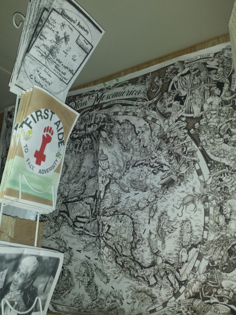 A shelf holds three zine titles. In the background is a Beehive poster