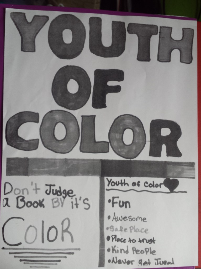 A poster designed by youth of colour that reads in bold YOUTH OF COLOR with a thick line under it. Below that is two sections on reads "Don't judge a book by it's color" and the other lists fun, awesome, safe place, place to trust, kind people, and never get judged.