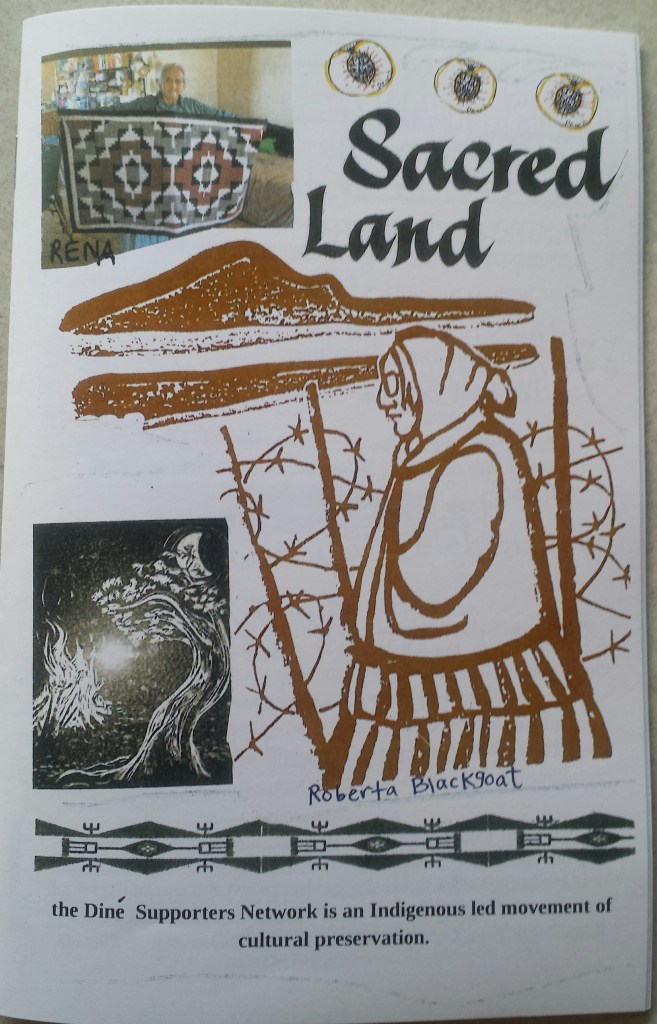Zine cover of Sacred Land. thick brown-red outline drawing of Roberta Blackgoat is center right aftont a bobwire fence and Big Mountain. Rena Babbit Lane arms wide displays her hand woven rug.