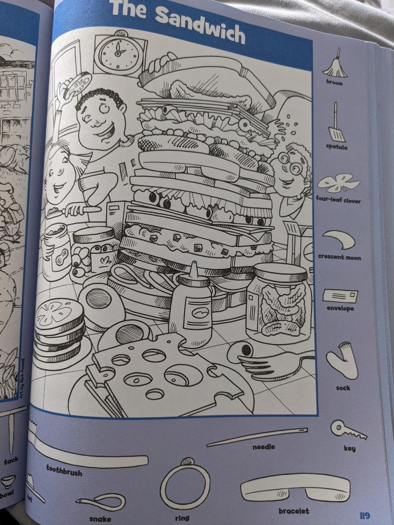 A colouring page of a tall sandwich and 3 people behind it. On the edge of the page are other labeled images to find within the main colouring page.